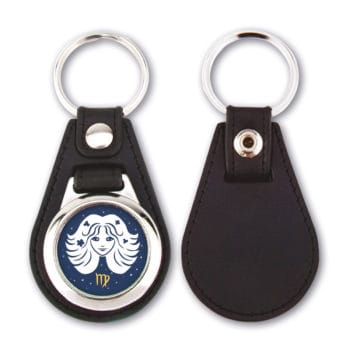 Ein schwarzer Lederschlüsselanhänger mit einem Widder-Sternzeichen auf einem runden Metallemblem.