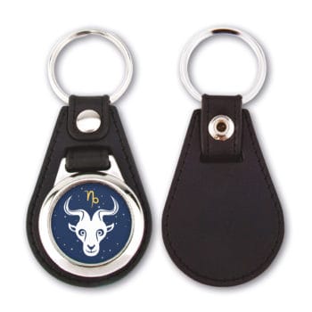 Zwei schwarze Leder-Schlüsselanhänger, jeweils mit Widder-Symbol und Widdergesicht auf Sternenhintergrund.