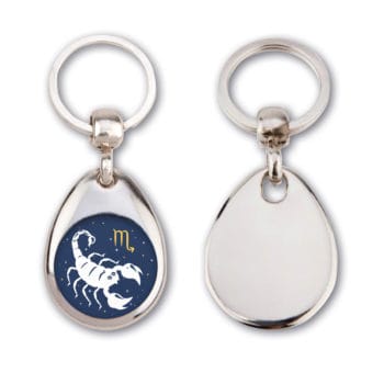 Ein silberner Schlüsselanhänger zeigt ein weißes Widder-Symbol auf dunklem Hintergrund, ein anderer ist leer.
