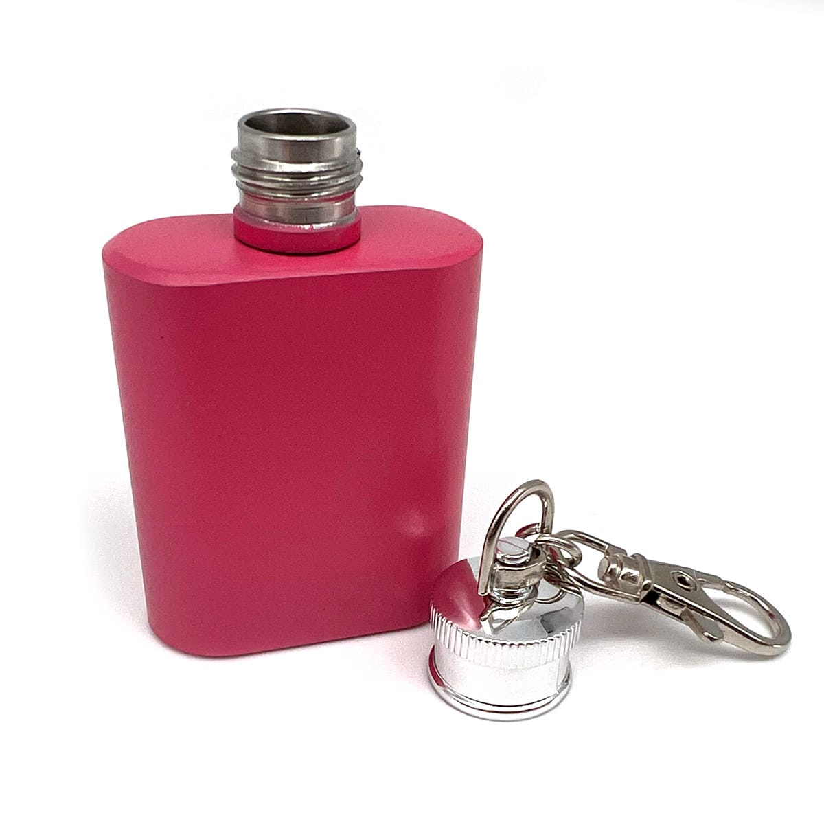 Kleiner rosafarbener Flachmann mit silbernem Schraubdeckel und Schlüsselanhänger, der Deckel wird abgenommen und daneben gelegt.