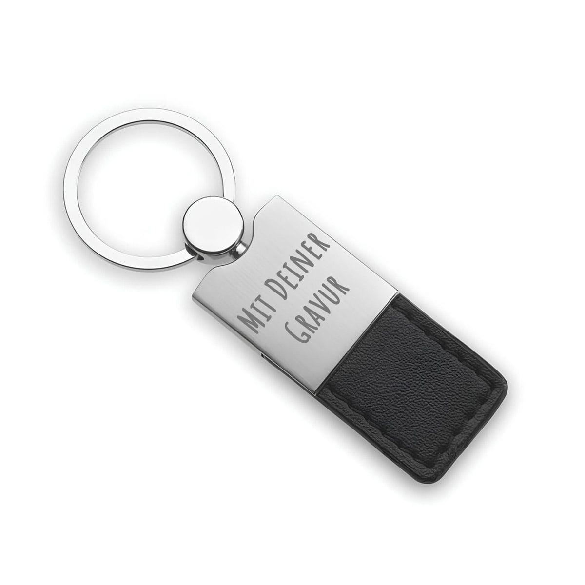 Ein Schlüsselanhänger aus Metall und schwarzem Leder mit der Gravur "MIT DEINER GRAVUR" auf dem Metallteil.