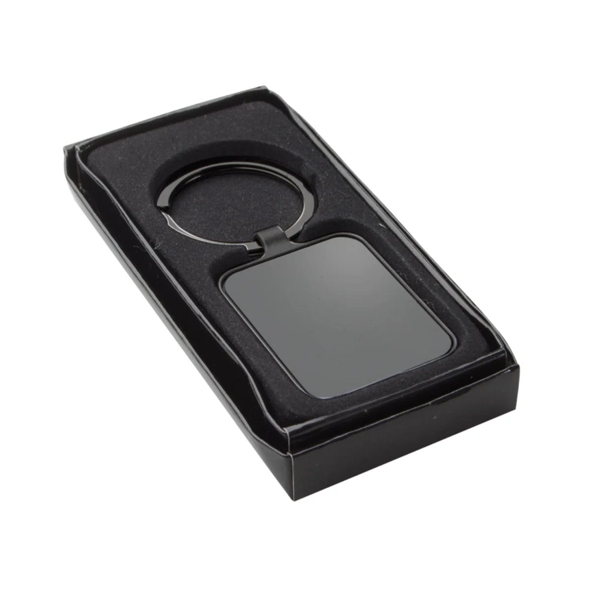 Schwarzer rechteckiger Schlüsselanhänger in einer schwarzen Geschenkbox mit Schaumstoffauskleidung, von schräg oben betrachtet.